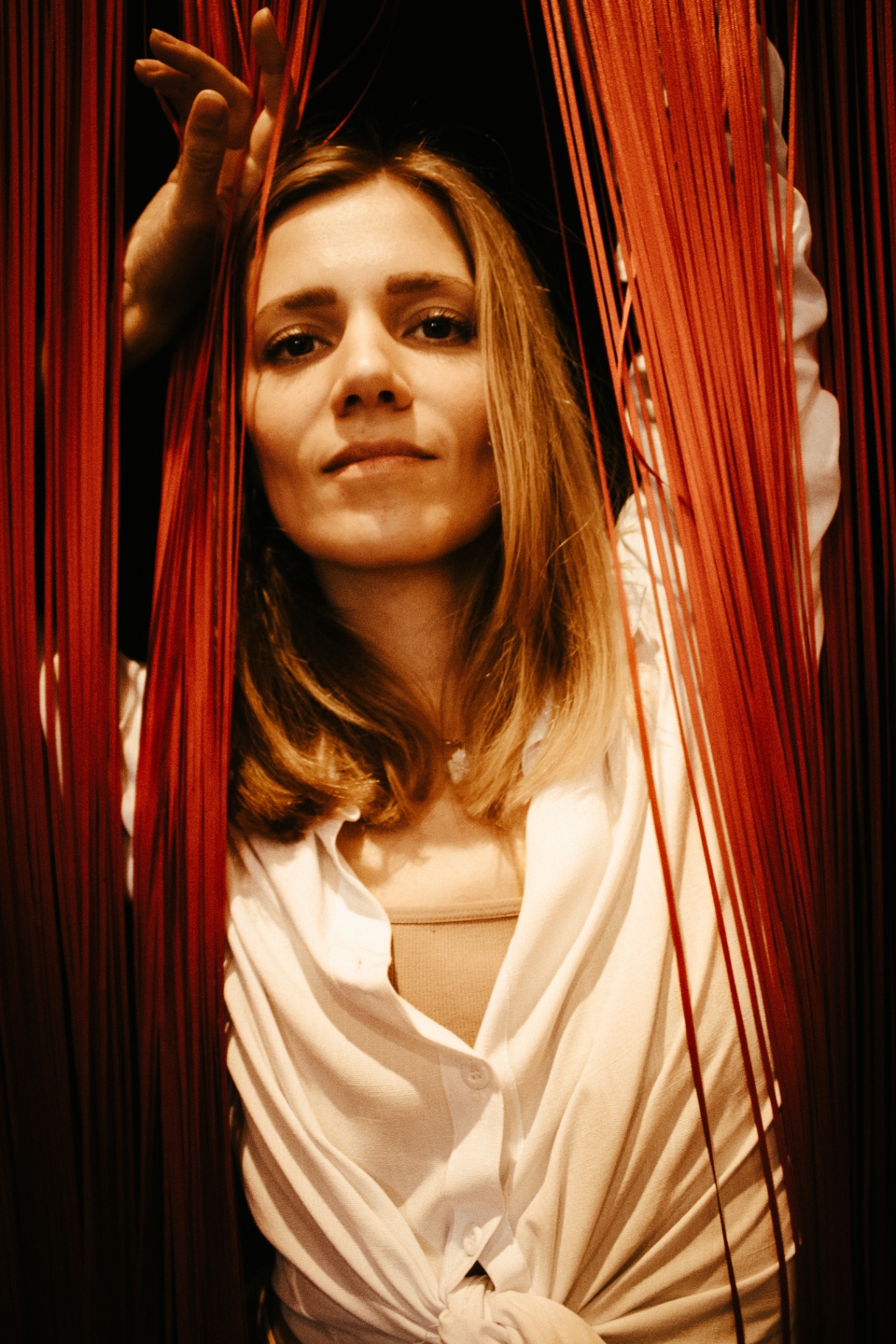 Alena — retrato entre cortinas vermelhas